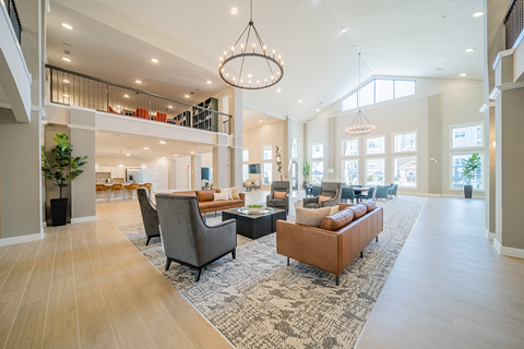 a lobby with sitting areas and a chandelier at a senior apartment community