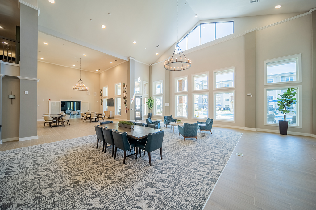 a large living room with a dining room table and chairs
