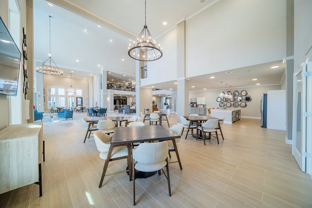 a large dining room with tables and chairs and a kitchen
