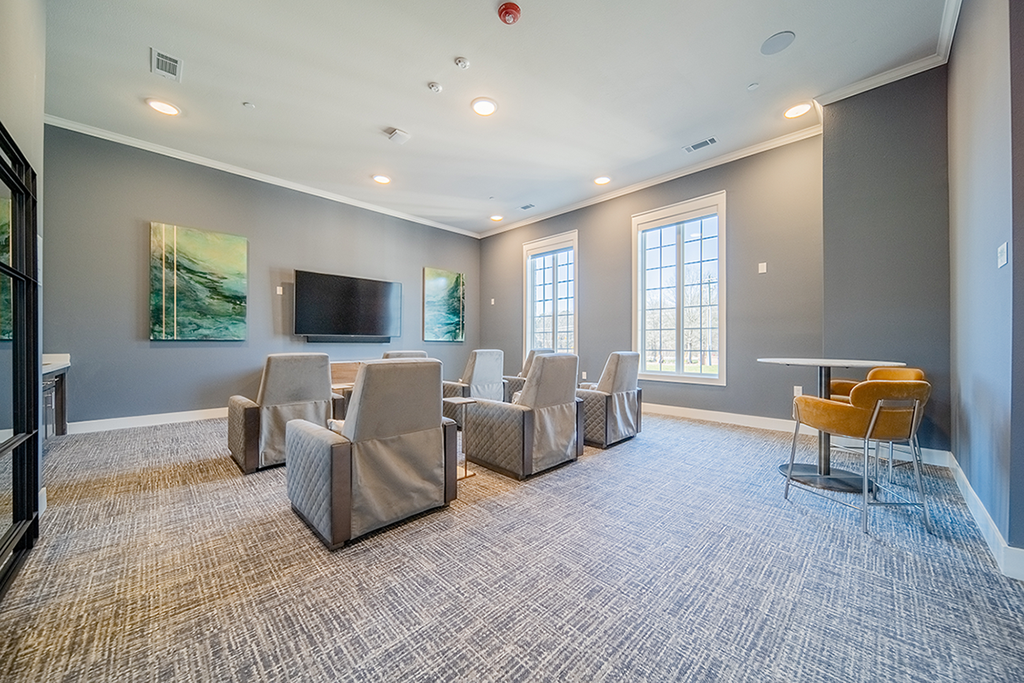 a community room with chairs and a table and a television