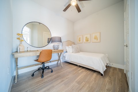 a bedroom with a bed and a desk with a mirror