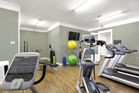 a gym with fitness equipment and machines at a senior apartment community
