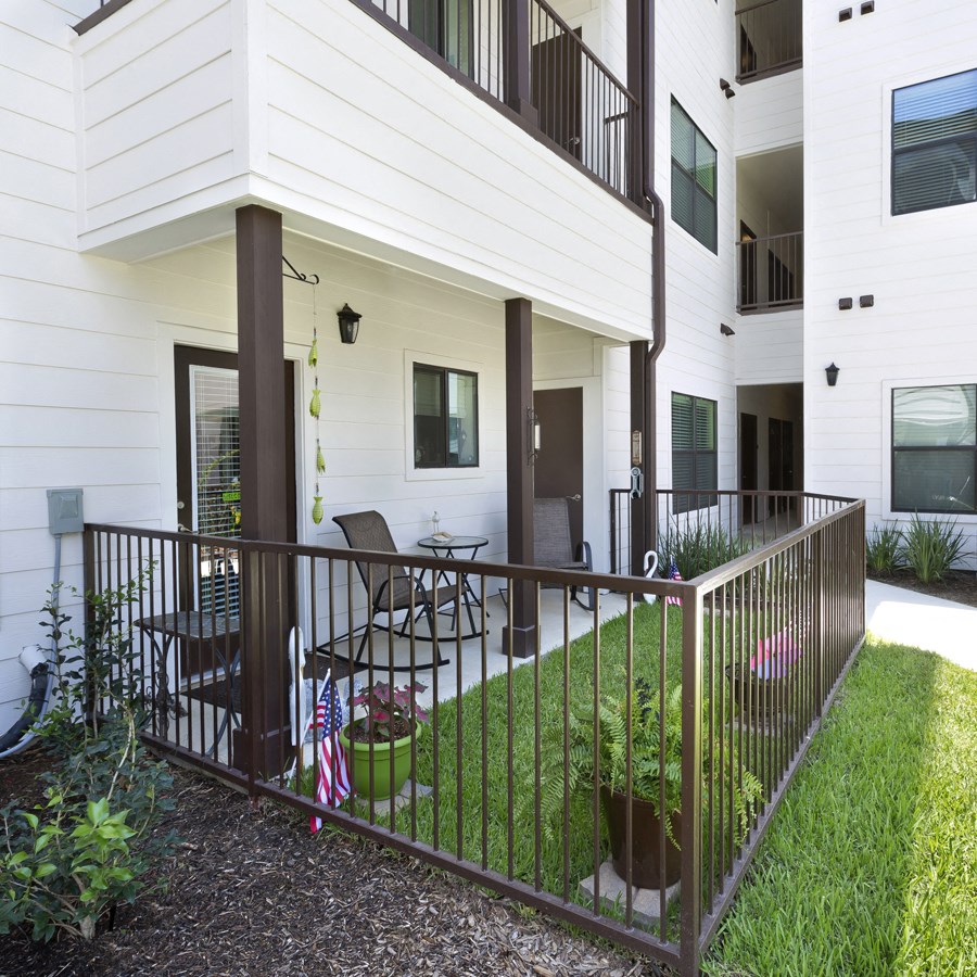 a balcony with a table and chairs in front of a building