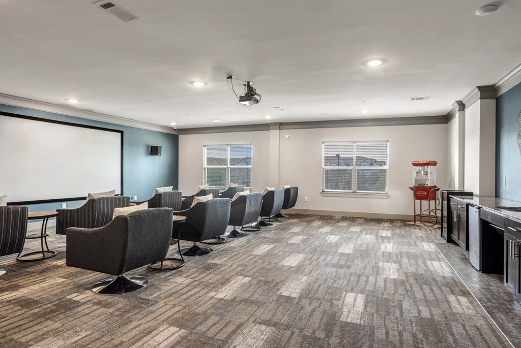an empty conference room with chairs and a projector screen in front of a whiteboard