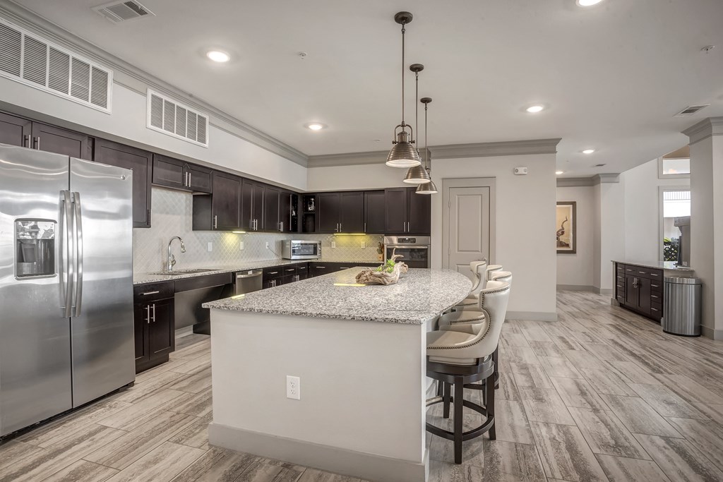 a kitchen with a large island and stainless steel appliances