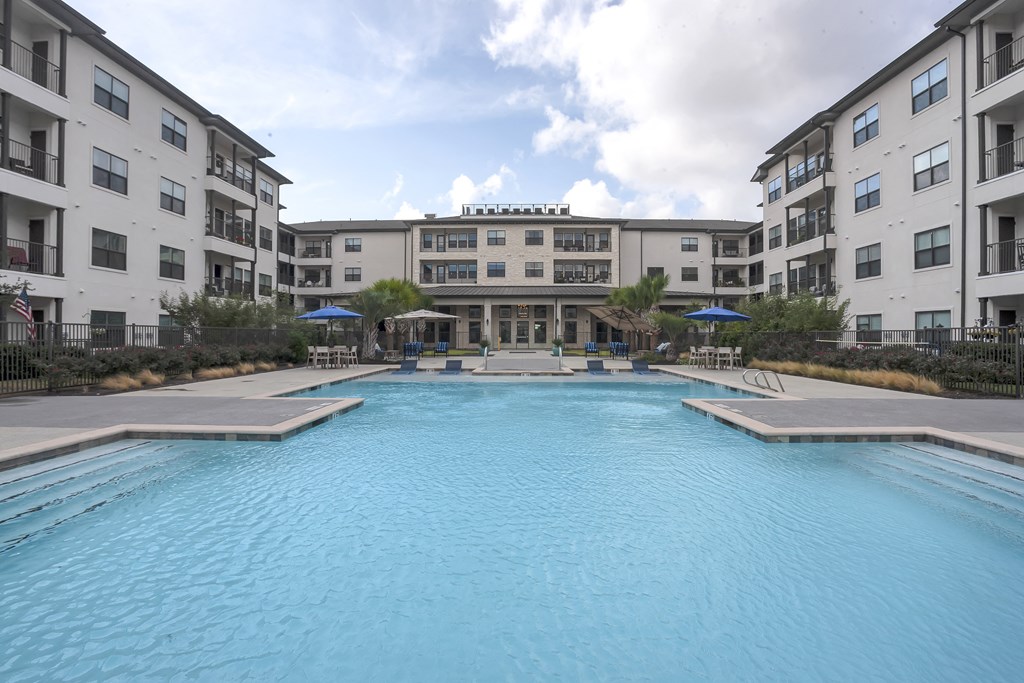 a large swimming pool in front of an apartment building