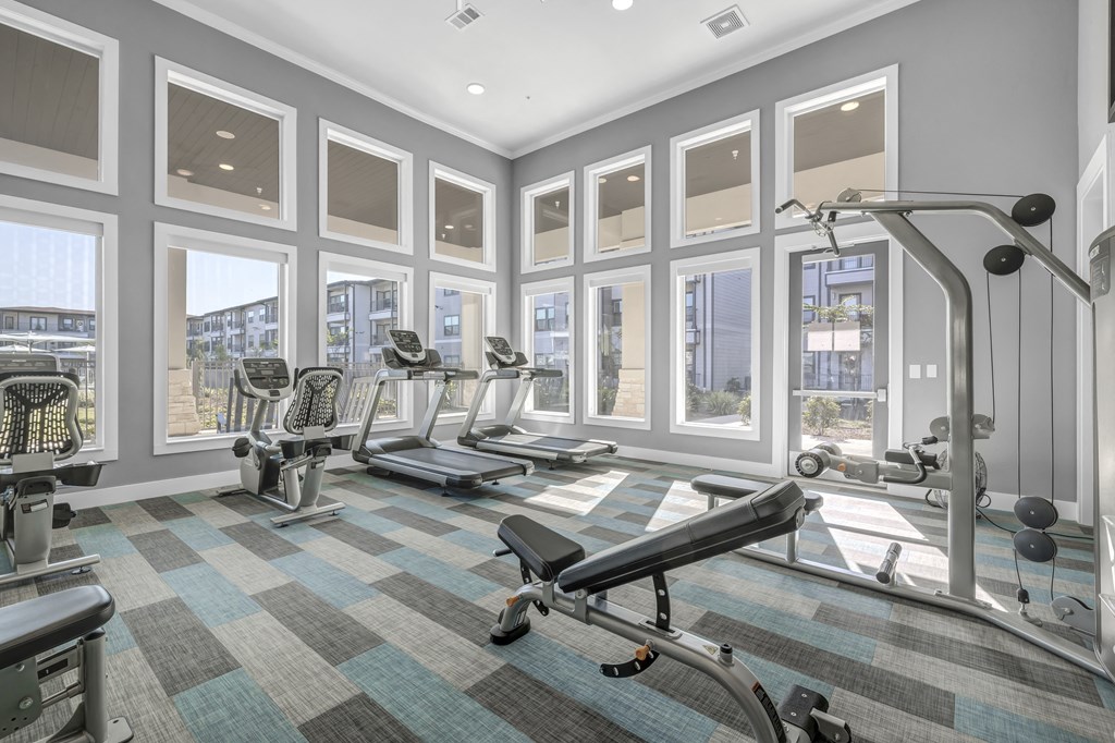 a gym with fitness machines and equipment at a senior apartment community