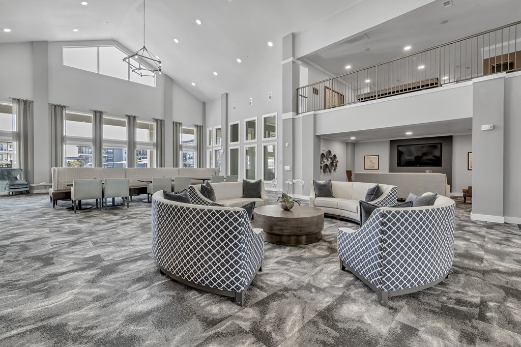 a large lobby with vaulted ceilings and sitting areas at a senior apartment community
