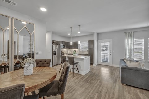 a living room with a dining room table and a kitchen