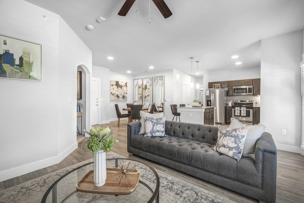 a living room opening up to a dining area and kitchen at a senior apartment community