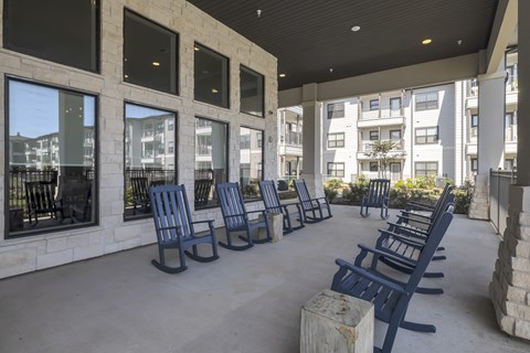 rocking chairs under a covered patio at a senior apartment community