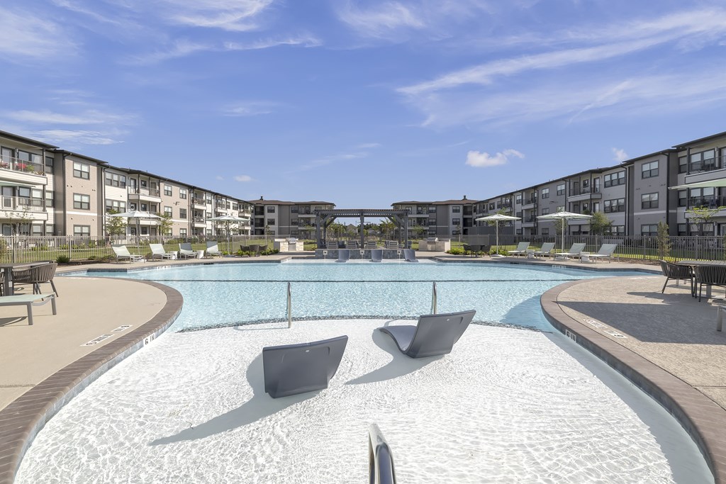 a resort-style pool and patio at a senior apartment community