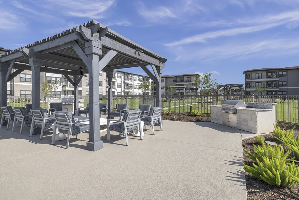 a poolside sitting area under a wooden pergola at a senior apartment community