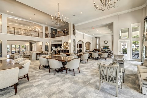 a communal clubhouse dining room with tables and chairs at a senior apartment community