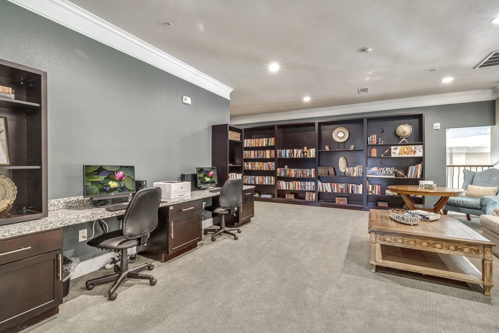 an office with two desks and a book shelf