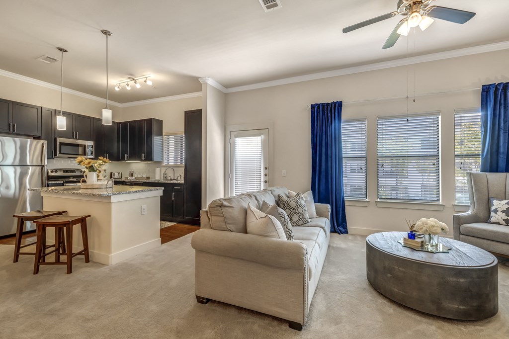 a living room and kitchen with a couch and a table