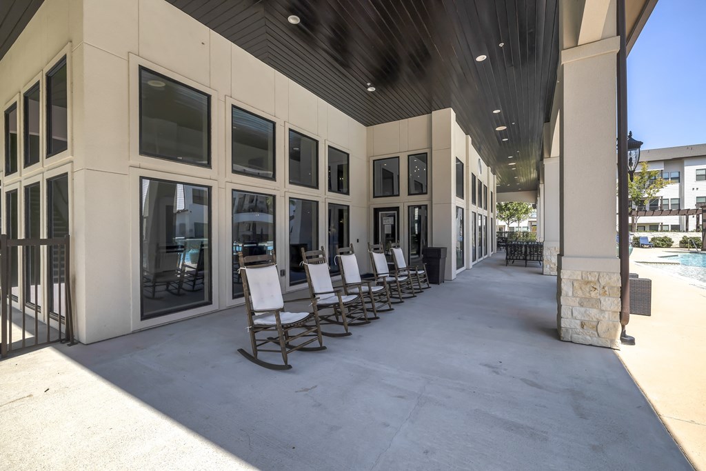 a row of chairs on a sidewalk outside a building