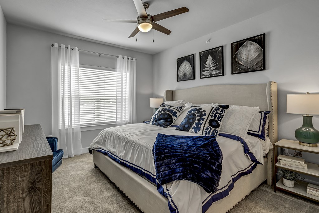 a bedroom with a bed and a ceiling fan