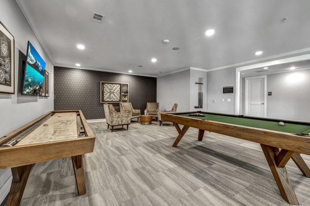 a billiards room with two pool tables and a tv