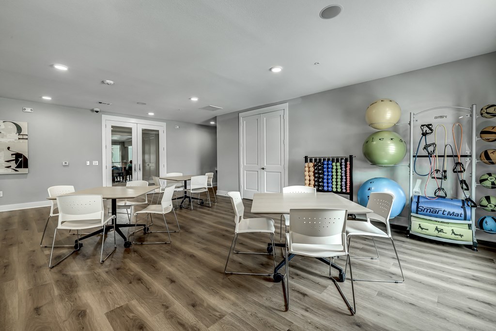a dining room with white tables and chairs and a play area