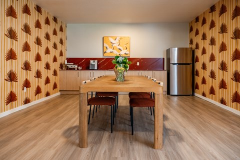 Dining area with wood table and kitchenette at The Teale Golden Gate Apartments, Naples, FL