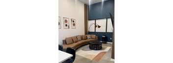 A living room with a brown couch, a coffee table, and a rug at The Lady, Columbia, SC