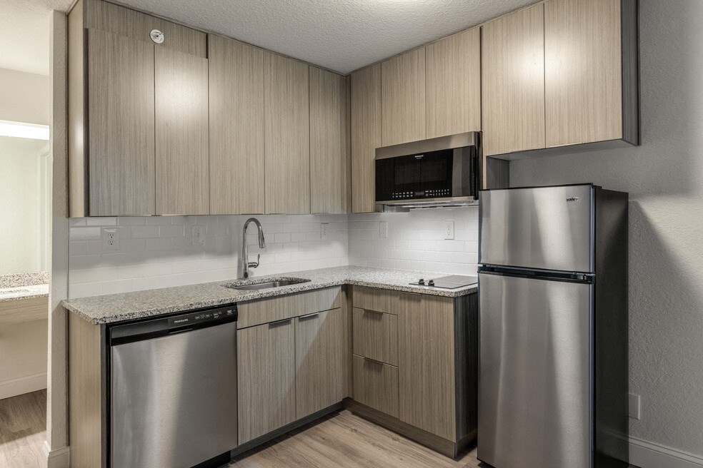 a kitchen with stainless steel appliances and wooden cabinets