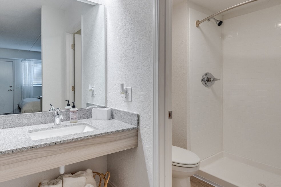 a bathroom with a sink and a shower and a mirror at The Teale, Kissimmee, FL, 34746