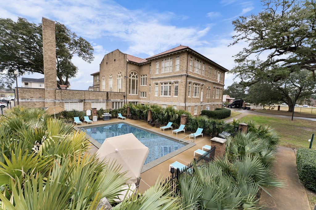 a swimming pool in front of a brick building