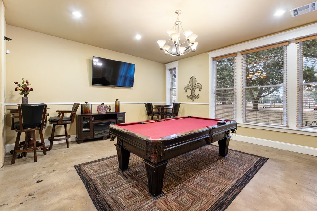 a game room with a pool table and a tv