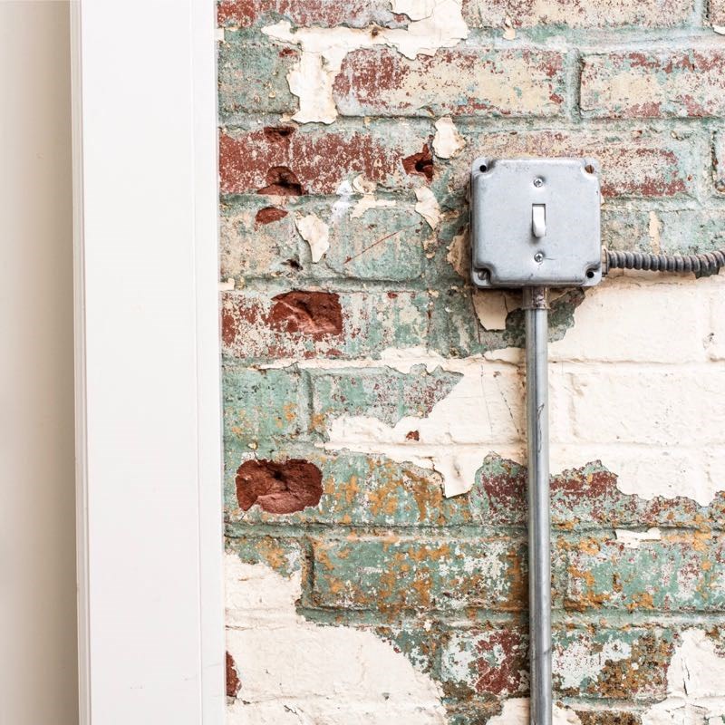 an electrical outlet on the side of a brick wall