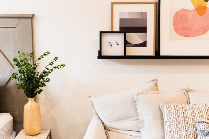 a living room with a white couch and a vase with a plant