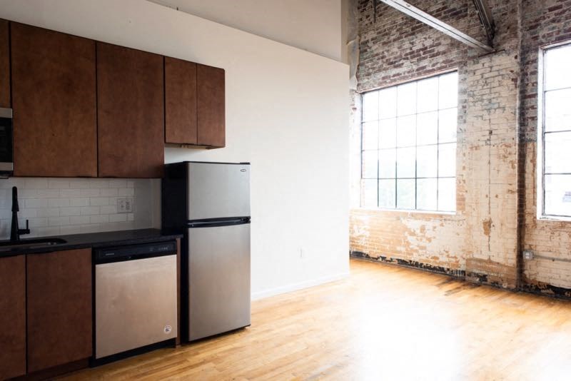 an empty kitchen with a stainless steel refrigerator