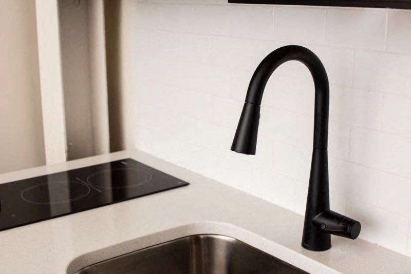 a black kitchen sink with a black faucet