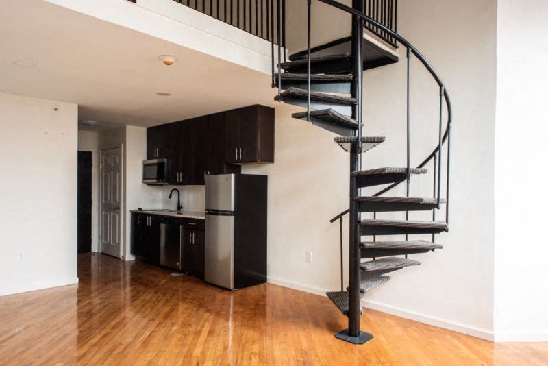 a spiral staircase in a living room next to a kitchen