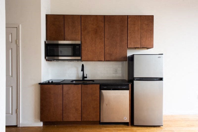a small kitchen with a refrigerator and a microwave