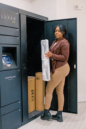 a woman holding a package in a locker at The Roseberry, Columbia, 29223