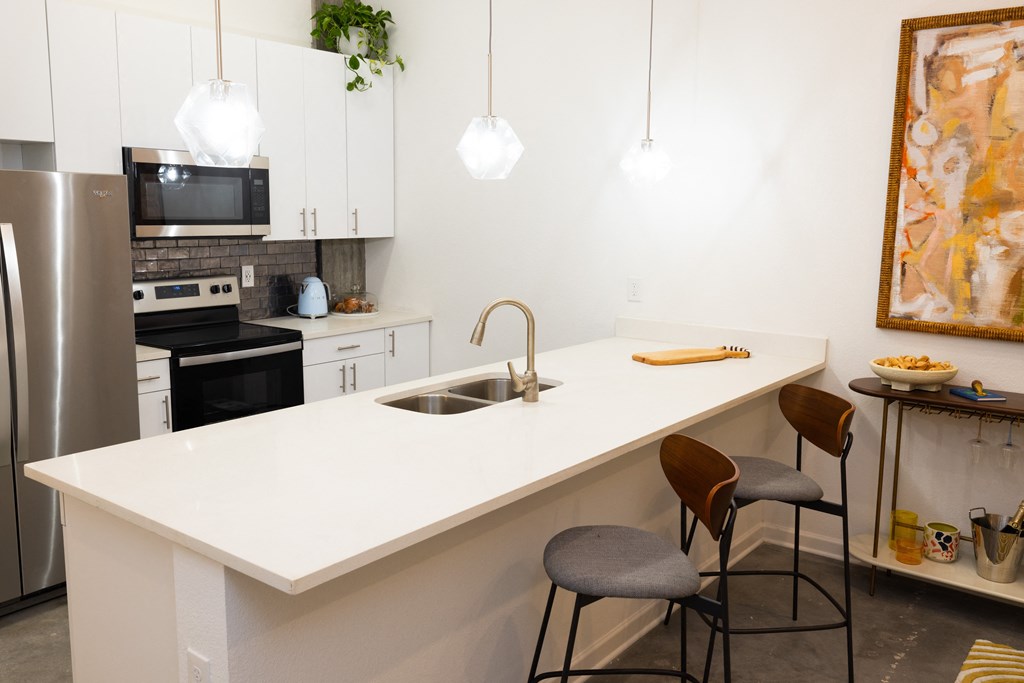a kitchen with a white counter top and a sink  at The Lady, Columbia, SC, 29201
