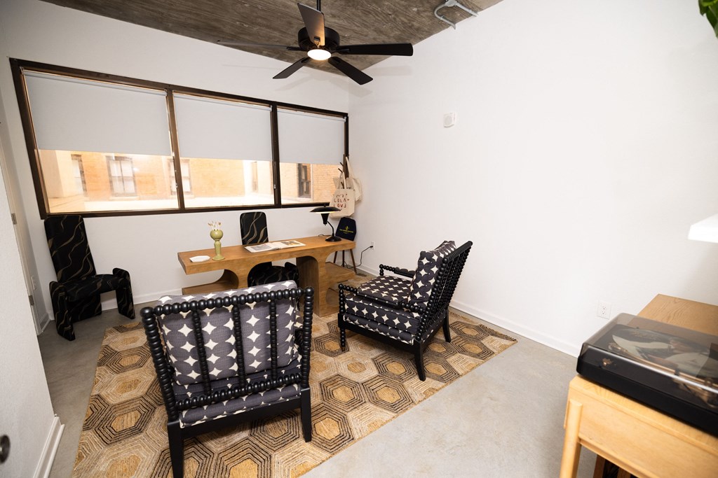 a living room with two chairs and a desk and a ceiling fan  at The Lady, South Carolina, 29201