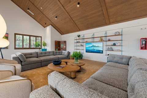 A living room with a grey couch and a wooden coffee table.