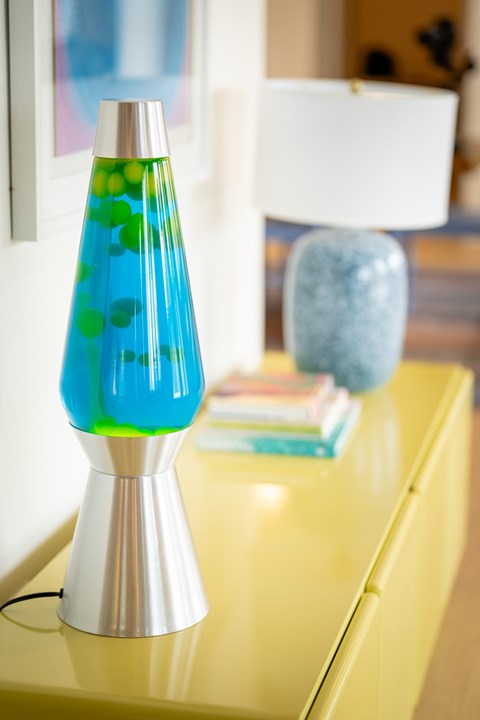A blue and green lamp on a yellow table.
