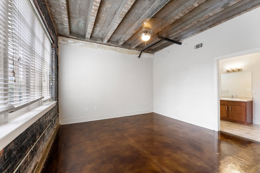 an empty room with a large window and white walls