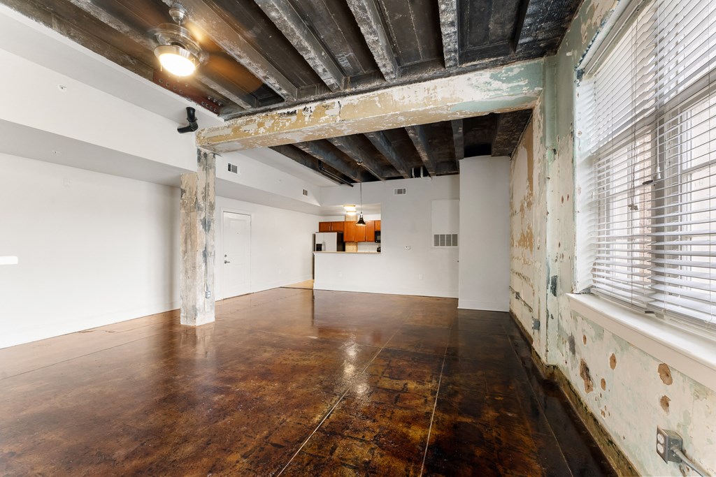 an empty room with a large window and wood floors