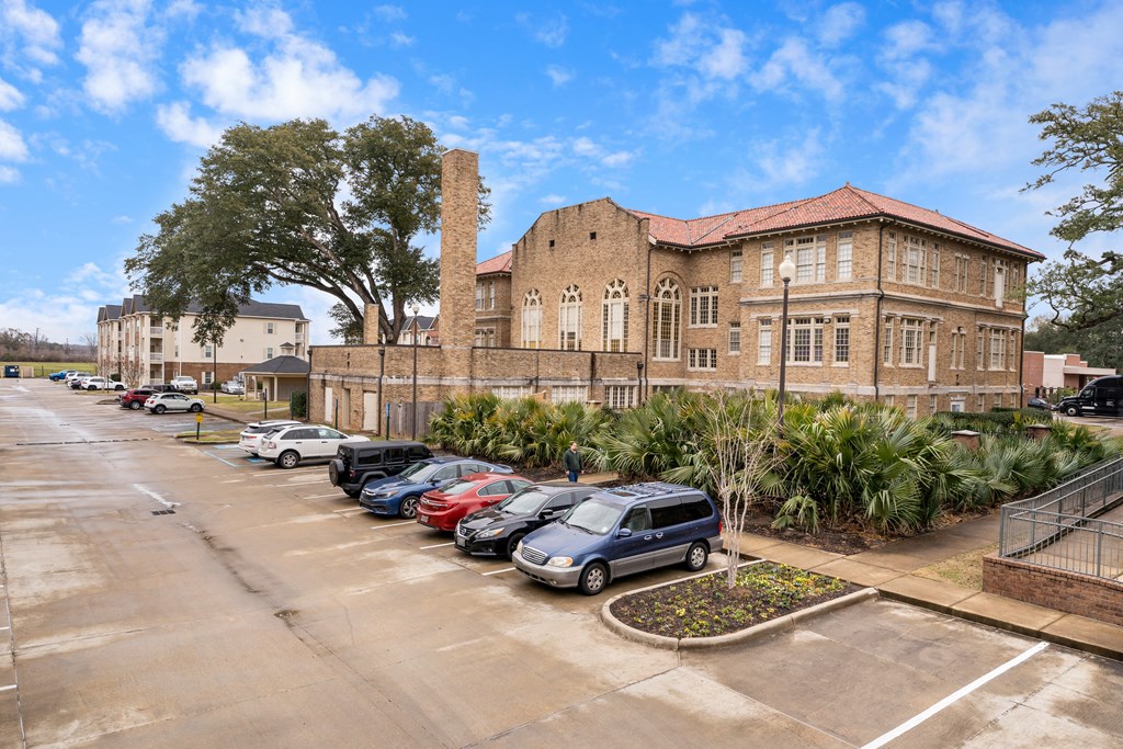 a large brick building with cars parked in a parking lot