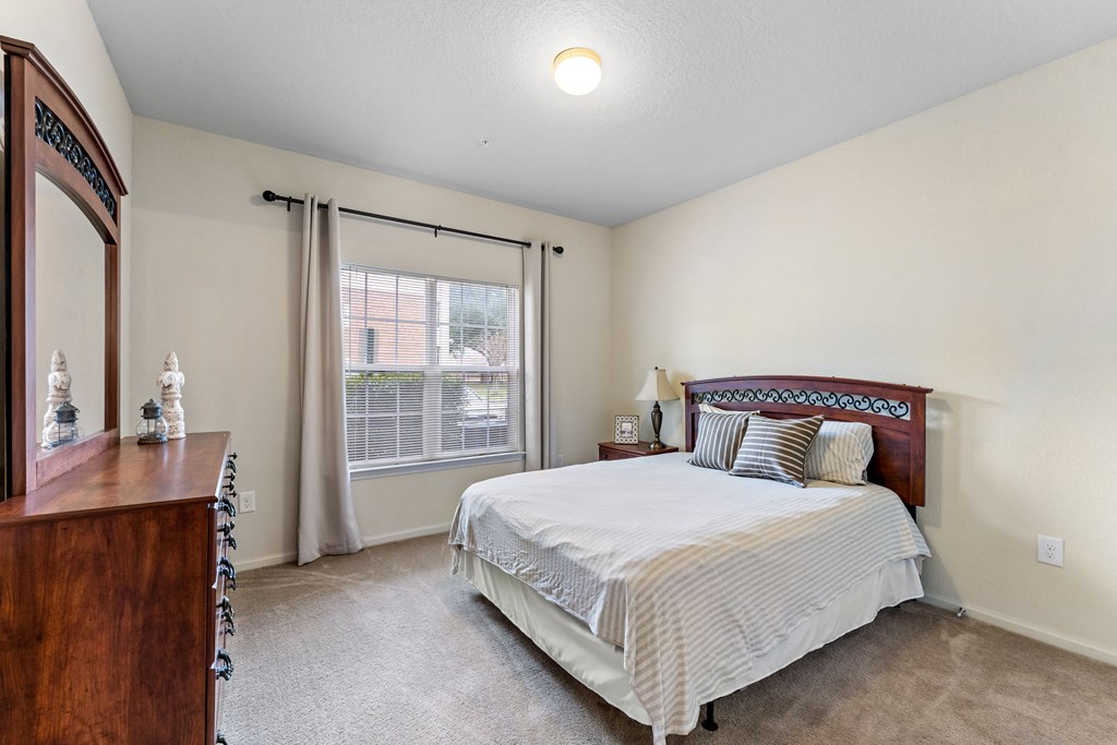 a bedroom with a bed and a dresser and a window