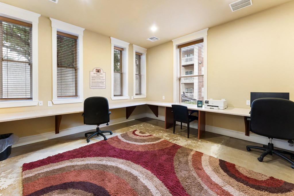 an office with desks and chairs and a rug