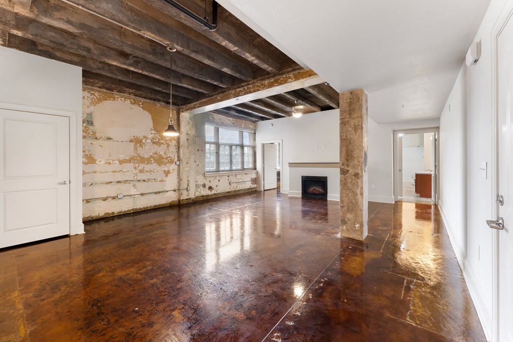 an empty living room with wood floors and exposed beams