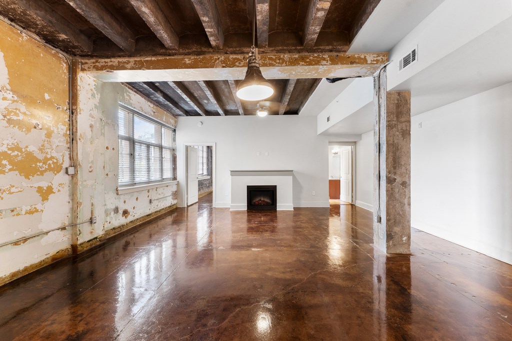 an empty living room with white walls and a fireplace