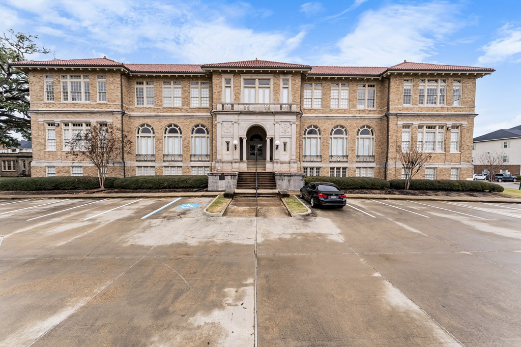 a large brick building with a car parked in a parking lot
