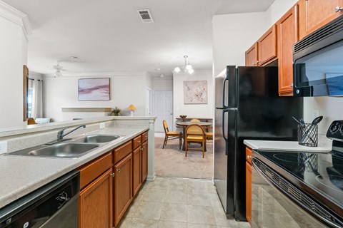 full kitchen with stainless steel appliances and wood cabinets and a dining room with a table